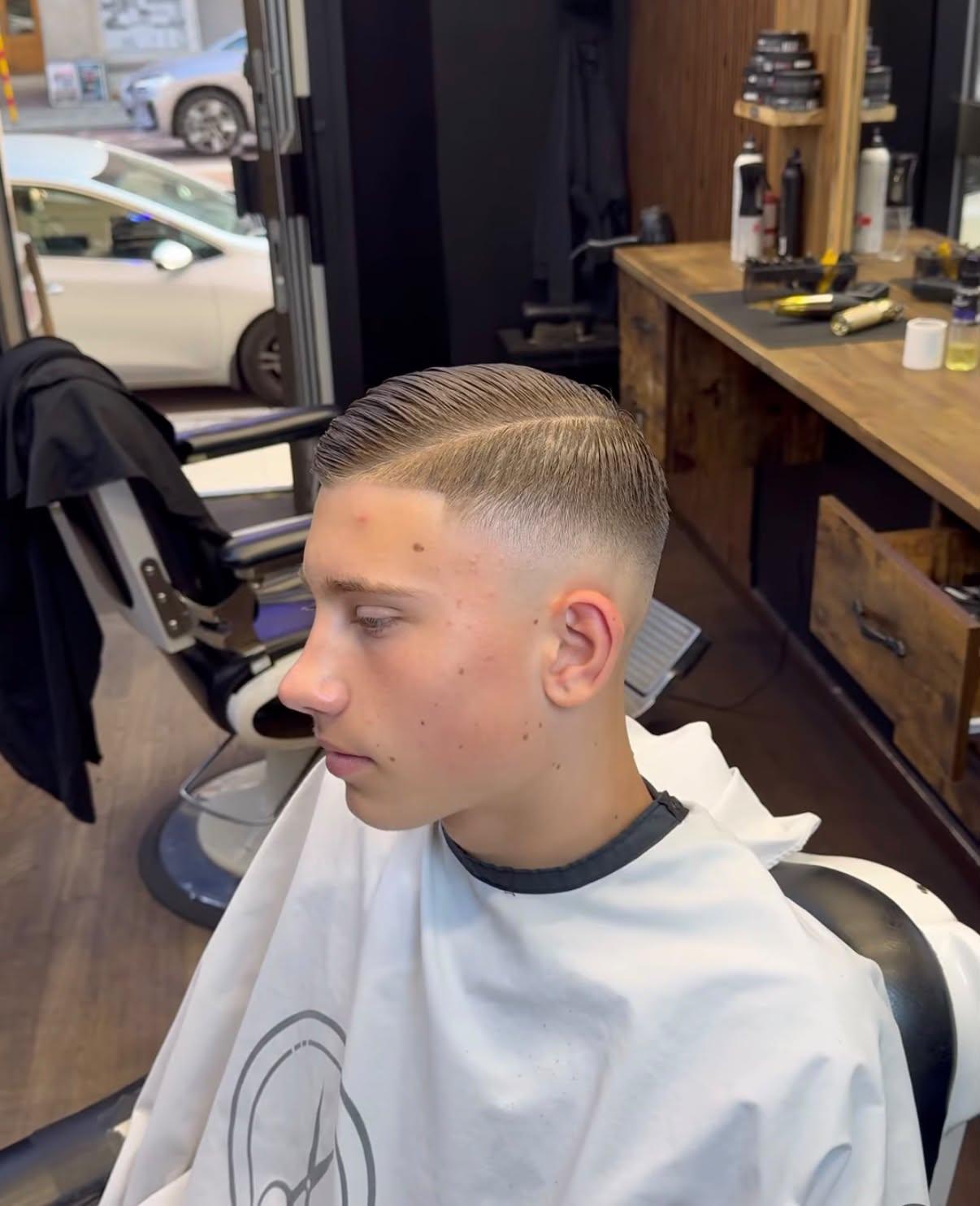 Sidbenad frisyr med skin fade, sedd från sidan